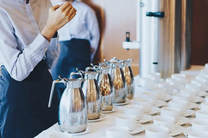 Staff set out coffee pots and cups for breakfast
