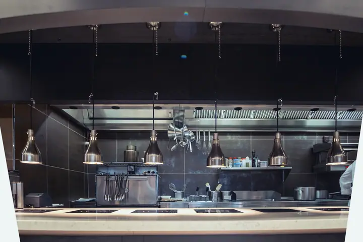 Empty professional kitchen late in the evening, the heat lamps still on